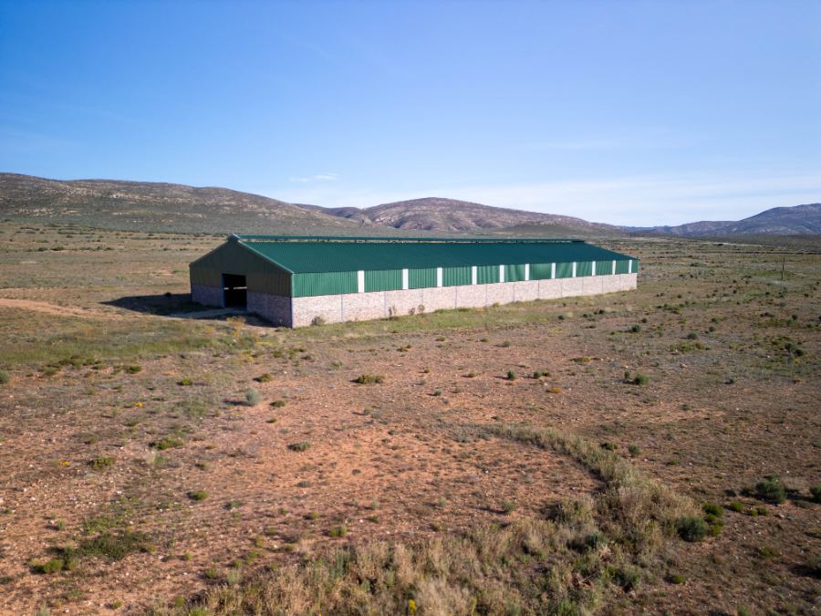 Large green-roofed shed standing in open veld